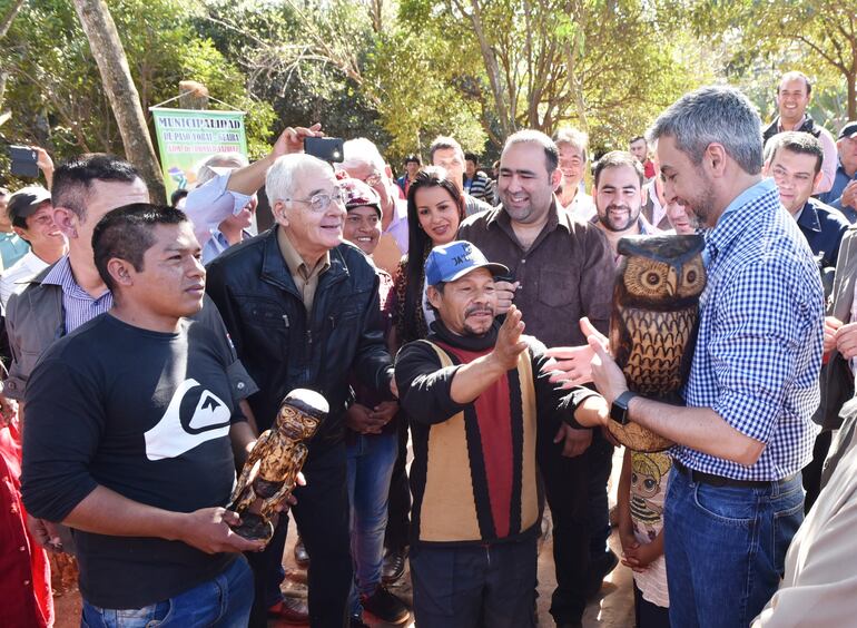 Momento en que uno de los nativos regaló su artesanía de tallado en madera al presidente de la República, Mario Abdo, durante una visita oficial en un comunidad indígena en Paso Yobái. Foto archivo.