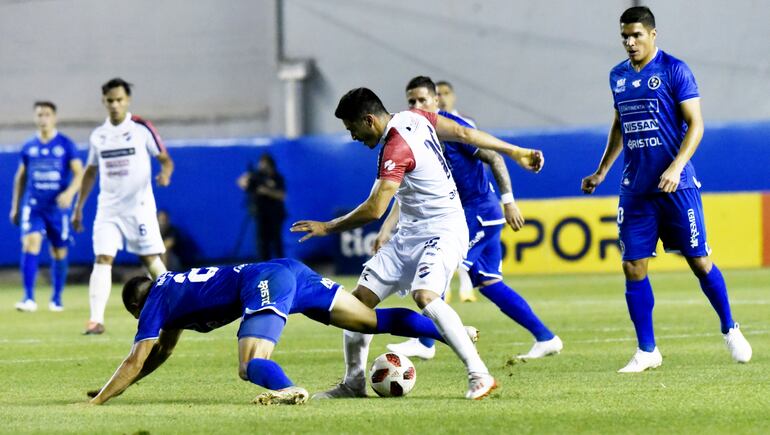 Enredo en las cercanías del área de Sol de América, donde el defensor Gustavo Velázquez va al suelo frente a Víctor Dávalos.