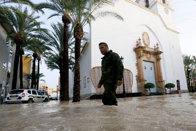 Un soldado camina por una calle inundada en la ciudad española de Dolores.