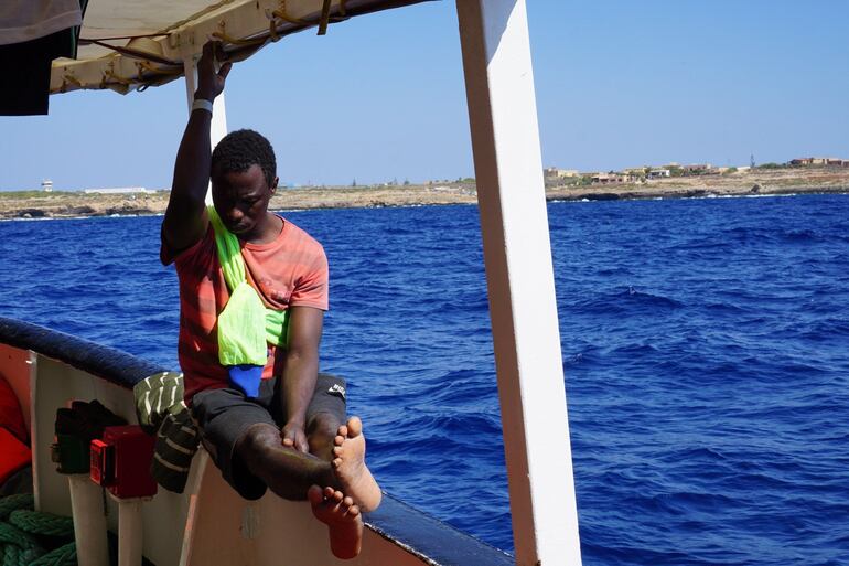 Un migrante a primera hora de este martes en el barco de la ONG española Open Arms, que sigue bloqueado desde hace 19 días frente a la isla italiana de Lampedusa.