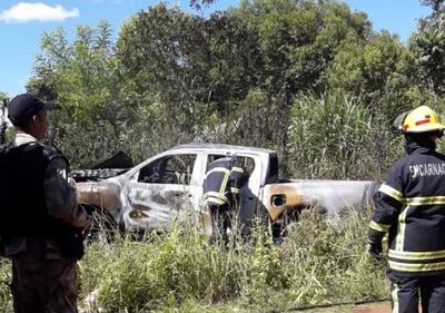 Bomberos voluntarios revisan la camioneta luego de extinguir las llamas.