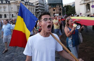 Un joven romano con una bandera de su país entona cánticos contra el gobierno, en una protesta contra el modo en que fue manejado el secuestro y probable muerte de una joven de 15 años.