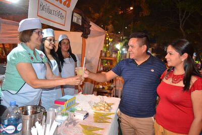 Uno de los visitantes recibe un vaso de siriki para refrescar la agradable noche misionera.