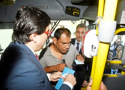 El viceministro de Transporte, Pedro Britos (izq.), explica el proceso a un usuario. Observa más atrás Mario Abdo Benítez.