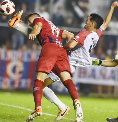 Ricardo Garay, defensor de Nacional, impide casi sobre la línea de gol la arremetida de cabeza de Diego Churín, hacia el final del intenso duelo entre vecinos.