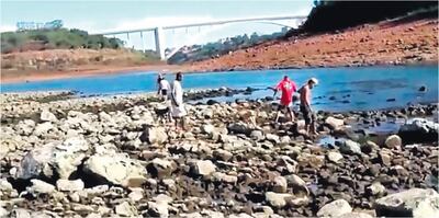 La gente  cruza el brazo del río Paraná para llegar hasta la isla Acaray, bajo soberanía brasileña.