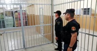 Funcionarios penitenciarios miran  hacia el acceso al pabellón, donde los criminales causaban destrozos en medio de un griterío infernal, supuestamente en reclamo de elementos de limpieza.