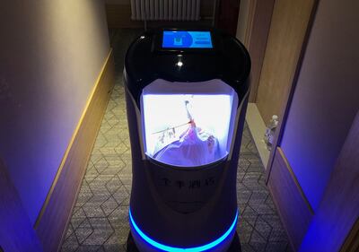 Un robot capaz de tomar ascensores y recorrer pasillos se usa para entregar comida a huéspedes en cuarentena en un hotel en Hubei, China.