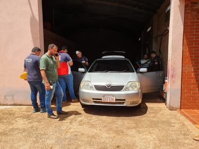 Agentes de criminalística inspeccionan el vehículo donde fueron encontradas muertas María Elizabeth Azcona Rodas (23) y su madre, María Luisa Rodas. Ocurrió hoy en Hernandarias.