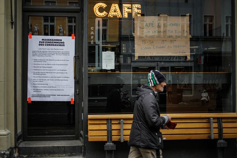 Un hombre pasa frente a una cafetería cerrada en Berlín, Alemania.