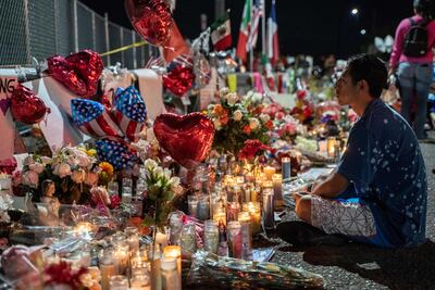 Un hombre se sienta frente a un memorial a las víctimas del tiroteo en El Paso, Texas.