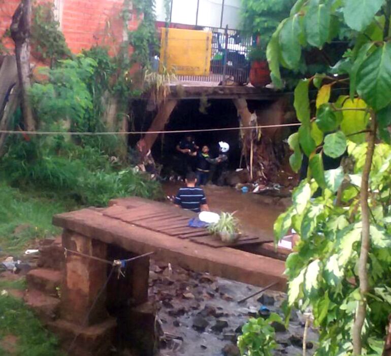 Agentes policiales sacan a empujones a uno de los delincuentes del arroyo al que se meti&oacute; intentando huir. Gentileza