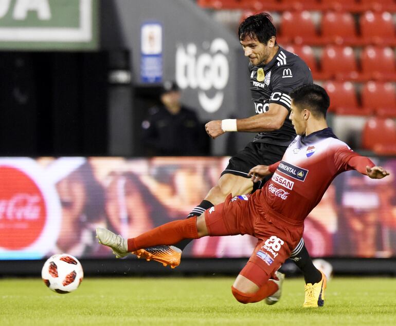 El remate de Roque Santa cruz para el segundo tanto de Olimpia que dio mayor tranquilidad al conjunto franjeado. El defensor albo Néstor Giménez no llega al cruce para impedir el disparo.