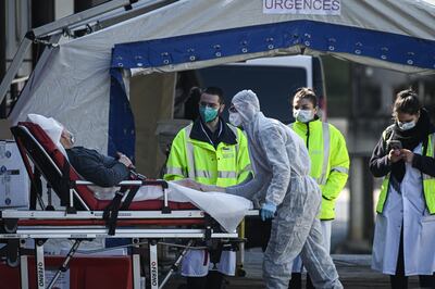 Personal médico atiende a un paciente con coronavirus a la entrada de la sala de emergencias montada en una carpa en el hospital Henri Mondor en Creteil, París.