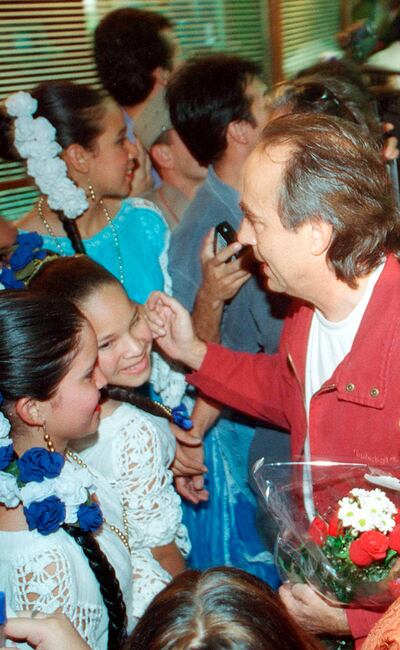 Serrat es recibido por unas niñas en el aeropuerto de Asunción, en diciembre de 2000, cuando presentó su disco “Cansiones”.