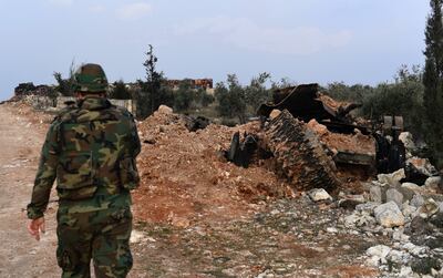 Un soldado del régimen sirio camina junto a un tanque destruido en el pueblo de Khan Tuman, en la provincia de Alepo.