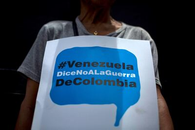 Una simpatizante chavista muestra un cartel que promueve el hashtag "Venezuela dice no a la guerra de Colombia" durante una movilización este jueves en Caracas, en defensa de la soberanía del país y en rechazo a las supuestas agresiones de la "oligarquía colombiana" y de EE.UU., países a los que el oficialismo acusa de buscar desestabilizar al Gobierno de Nicolás Maduro.