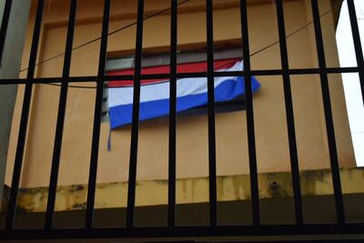 Una bandera paraguaya en una de las ventanas del Colegio Pedro P. Peña de Itauguá.