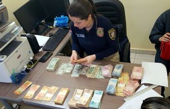 una-policia-de-investigaciones-de-canindeyu-cuenta-el-dinero-recuperado-de-la-casa-del-empleado-detenido-en-salto--201336000000-1840106.jpg