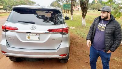 El chofer Alexis González junto a la camioneta demorada.