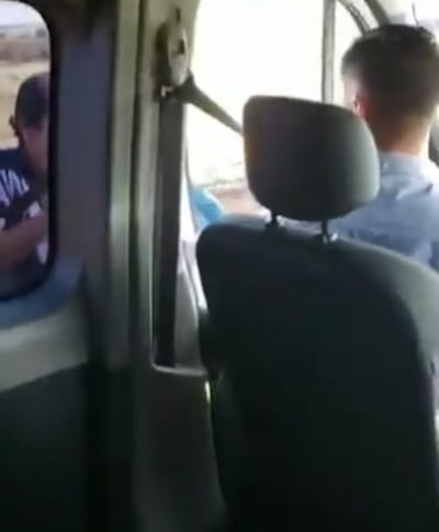 El momento en que uno de los asaltantes amenaza a los ocupantes del vehículo.