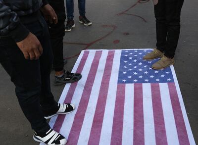Manifestantes pisan una bandera de Estados Unidos durante una protesta en Bagdad.