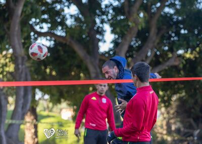 El entrenador Sergio Orteman impulsa el balón durante el juego recreativo del fútbol-tenis del Sportivo San Lorenzo.
