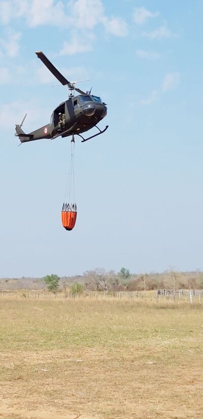Uno de los dos helicópteros Bambi con capacidad de transporte de 800 litros de agua se dirige a la zona del incendio para atacar los focos de fuego que se reavivaron.