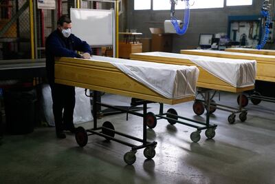 Un empleado cubre ataúdes en la fábrica de ataúdes Eurocoffin en Barcelona.