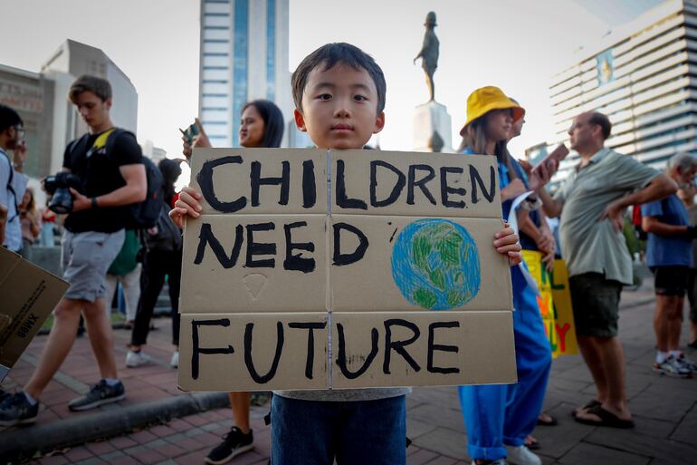 Un niño sostiene un cartel reclamando un futuro, en una manifestación en Tailandia.