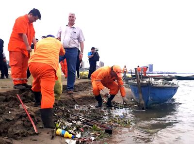 El ministro de Obras Públicas, Arnoldo Wiens (centro), observa la   limpieza que se realiza en la costa del río Paraguay.