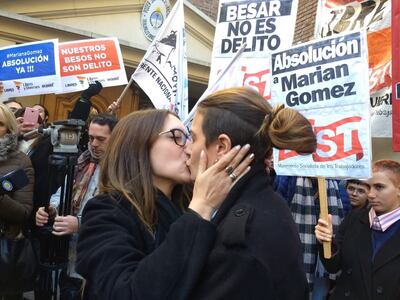 Mariana Gómez, con el pelo recogido, besa a su esposa.