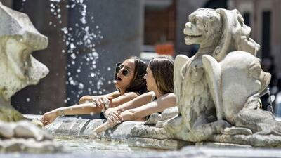 Dos turistas se refrescan en una fuente de Roma. Imagen de archivo, EFE.