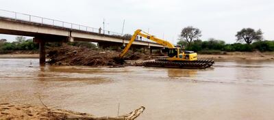 La retroexcavadora anfibia de la Gobernación de Boquerón  en plena tarea de limpieza de   los pilares del puente Pozo  Hondo-Misión La Paz (Argentina).