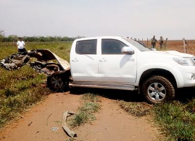 Un grupo de oficiales de la Policía verifica lo que quedó de la camioneta que fue alcanzada por la detonación del explosivo.
