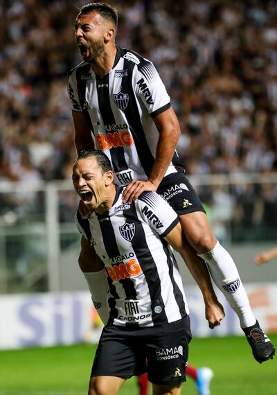 Ramón Martínez se trepa sobre el hombro de Ricardo Oliveira y festeja el gol de su compañero en la victoria del Atlético Mineiro sobre Fluminense.