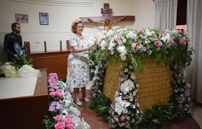 Doña Nidia de Kennedy observa el acabado del adorno de flores del pedestal de la Virgen de los Milagros de Caacupé.