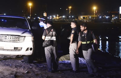 Peritos del Ministerio Público y agentes policiales realizan el procedimiento de rigor frente al cuerpo sin vida de Carlos León Forcado, cubierto con una sábana, tras ser sacado del agua.