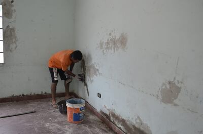 Nolberto Arroyo, director de la escuela 14 de mayo de San Antonio, revoca la pared de un aula.