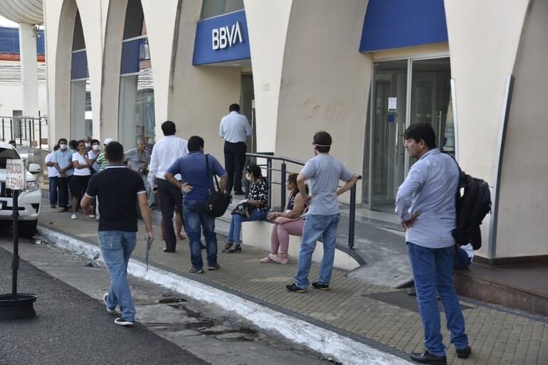 Los cajeros automáticos se encuentran llenos de gente formando largas filas para retirar su dinero hoy, en el último día del mes de marzo.