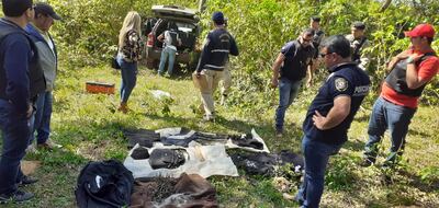 La comitiva policial-fiscal que realizó el allanamiento revisando las evidencias incautadas.