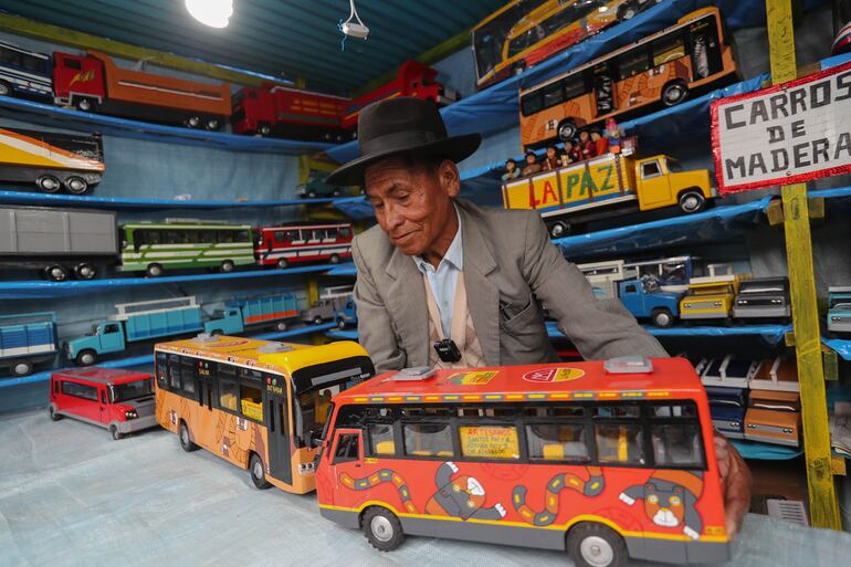 Un artesano boliviano muestra sus trabajos en la feria de la Alasitas, la tradicional feria de las miniaturas y los deseos,  en La Paz (Bolivia).
