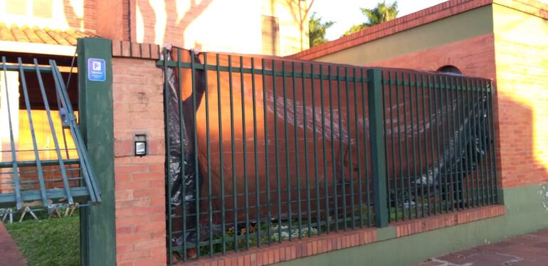 Empleados de Óscar González Daher cubren con un paño de plástico negro las rejas de la casa donde guardará prisión domiciliaria el político colorado.