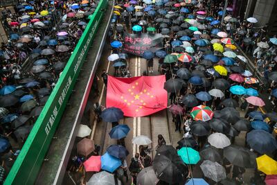 Manifestantes marchando con una pancarta que usa las estrellas de la bandera nacional china para representar un símbolo de la esvástica nazi en el distrito central de Hong Kong. (Imagen de archivo AFP).