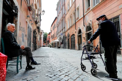 Ancianos protegidos con mascarillas conversan en el barrio de Trastevere, en Roma, Italia, este sábado. Varias regiones del sur de Italia han pedido mantener las restricciones de movimiento para contener la pandemia, después de que el norte, la zona más afectada por el coronavirus, esté presionando al Gobierno para acelerar la reapertura del país.
