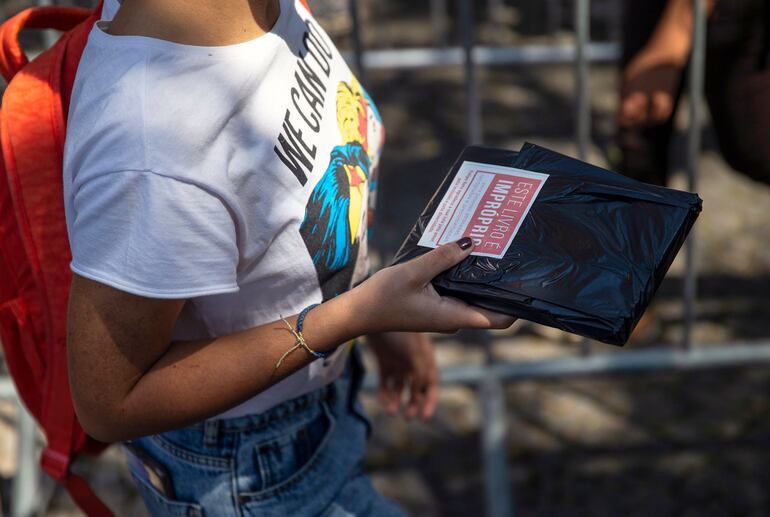 Una mujer muestra un libro de temática LGBT distribuidos de forma gratuita por el "youtuber" Felipe Neto en la Bienal de Río de Janeiro.