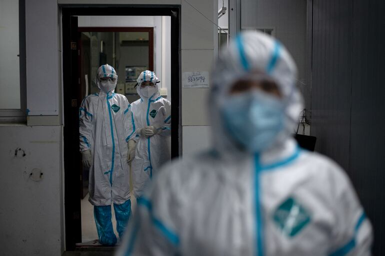 Trabajadores médicos con trajes protectores en un hospital de Huanggang, China.