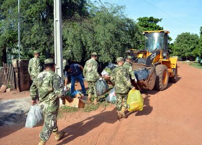 Efectivos de la 4ª División de Infantería depositaron basura en un tractor para llevar los desperdicios  hasta un camión volquete.