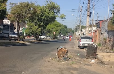 Los vecinos colocaron cuatro tambores en el pavimento para indicar el socavón del asfalto y advertir a los conductores. Dos de ellos están antes de llegar a la calle Pinzón.