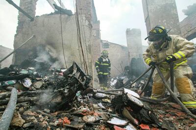 Bomberos trabajan para extinguir las llamas en los escombros de la Corte Electoral Departamental de Santa Cruz, Bolivia.
